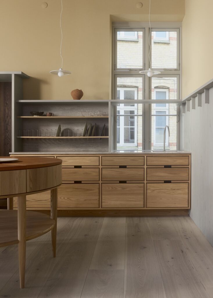 Close-up of wood paneling and shelves finished in Ash Oil with a Sahara Sand wall backdrop.