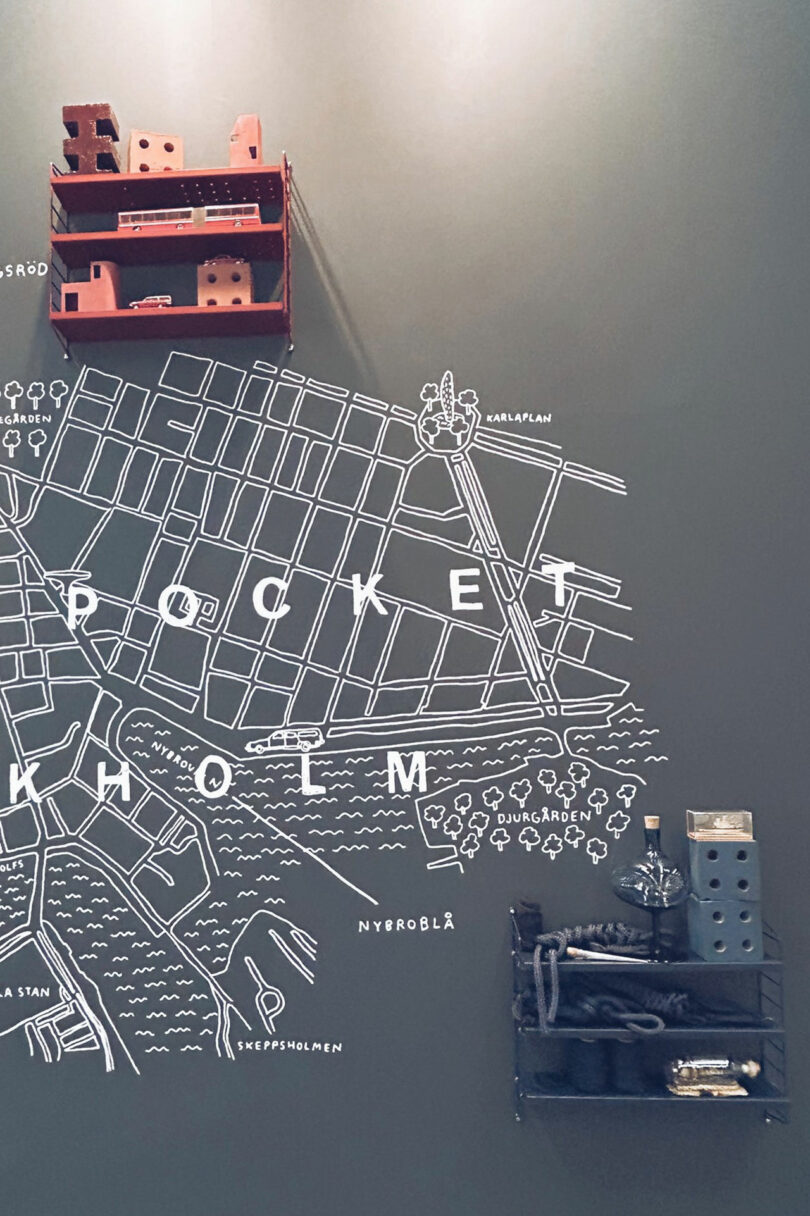 Modular shelves holding minimalist objects against a wall map backdrop.