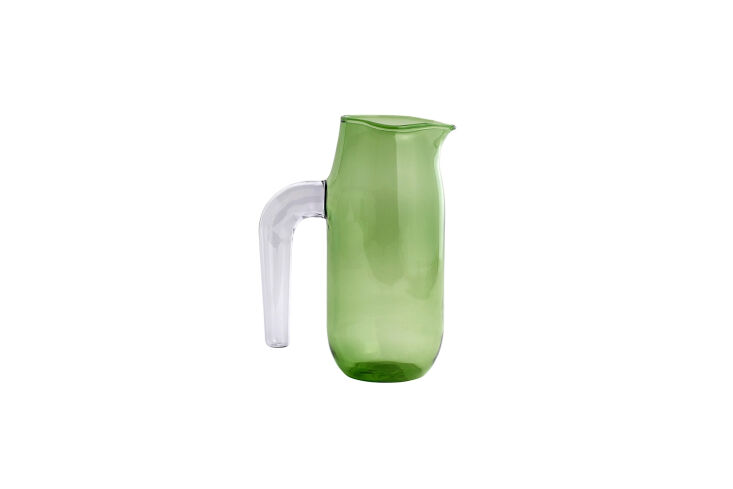 A Hay pink jug with a green handle used as a decorative accent.