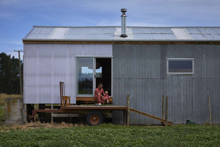 Large sliding glass door opening onto a wooden deck made from a repurposed hay trailer.
