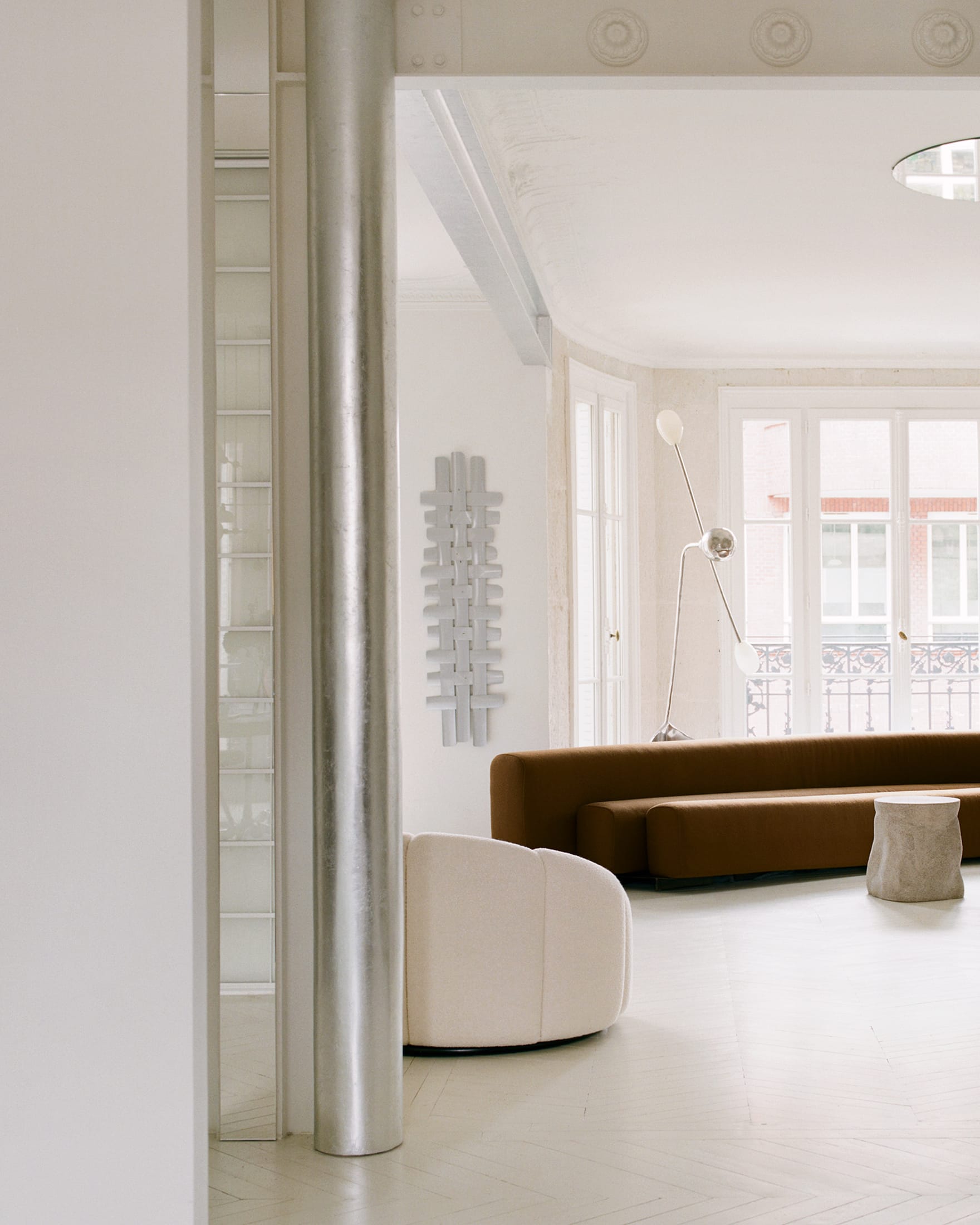 A serene room corner with layered neutral textures, soft lighting, and minimalist furniture.