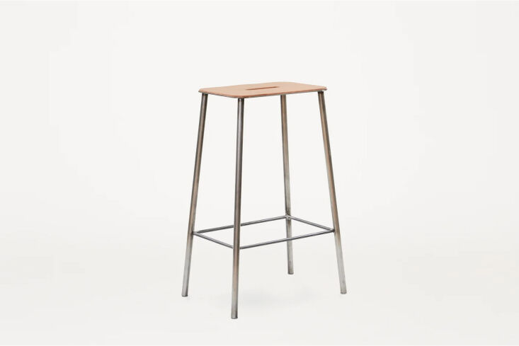 The Frama Adam Stool with a natural leather seat and raw steel frame.