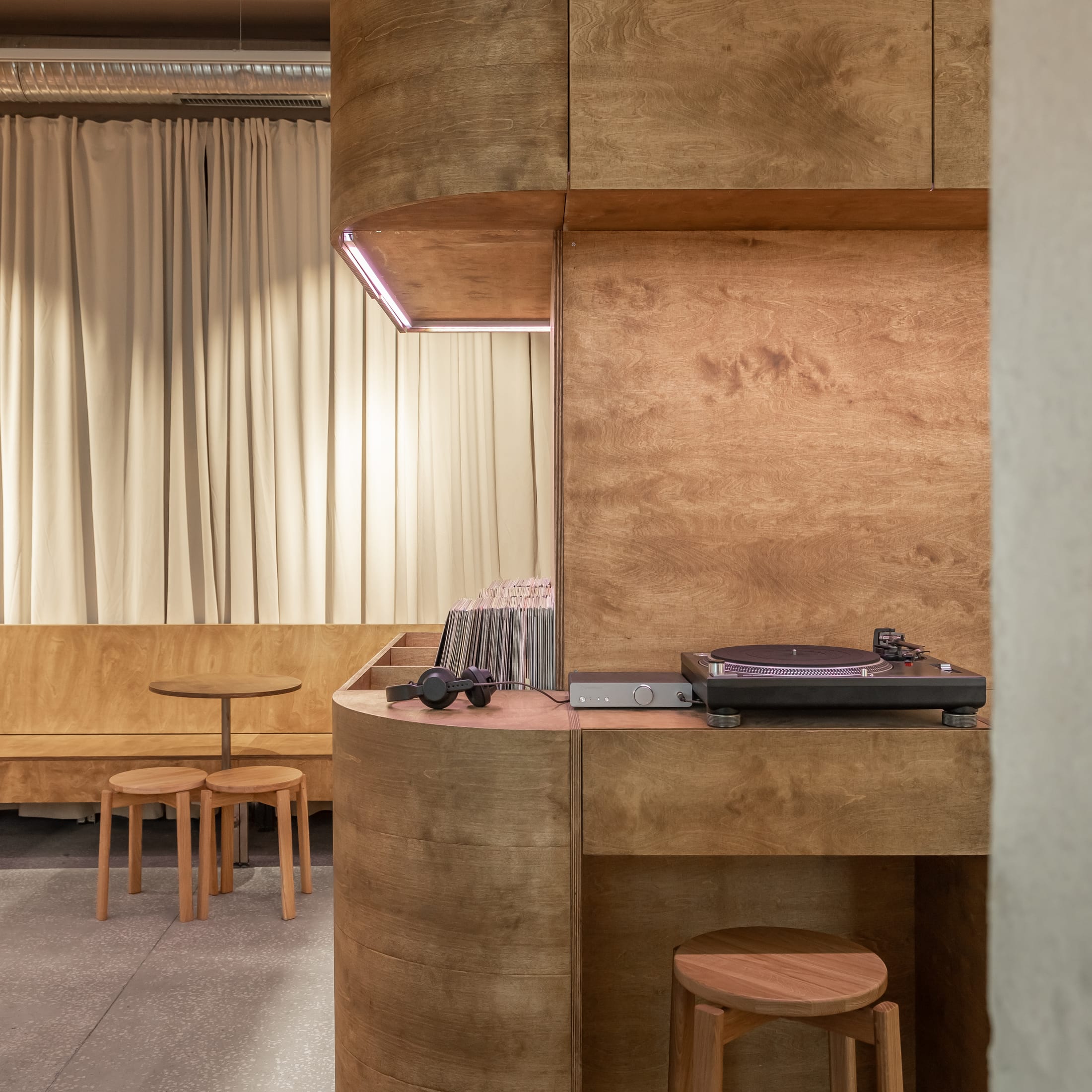 Evening shot of Bar Ton with warm lighting highlighting the acoustic textures and the bar area.