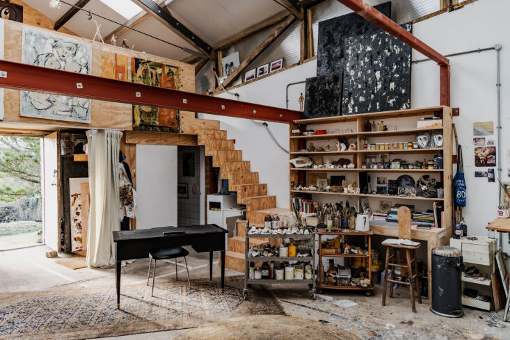 Large-scale artist studio with high ceilings, mezzanine level, and large gestural paintings.