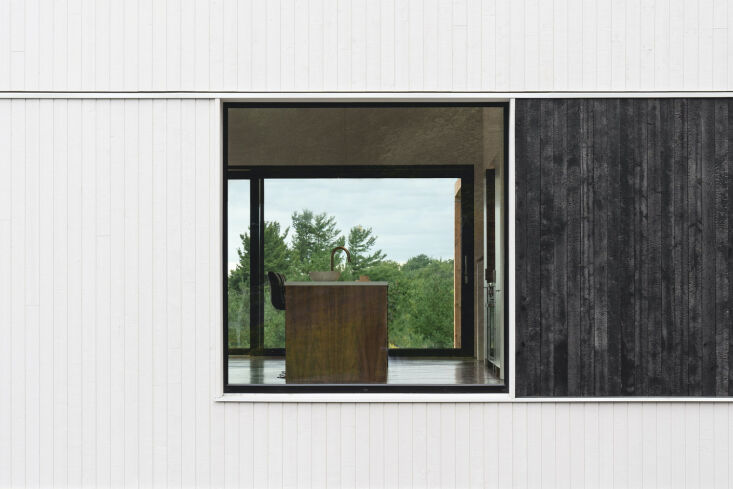 Close-up of the exterior siding featuring black shou sugi ban burnt cedar and grey painted spruce.