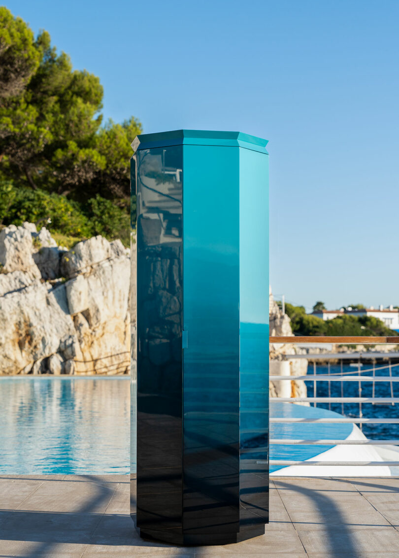 A glossy blue-green Ottagono monolith standing on a luxury patio.