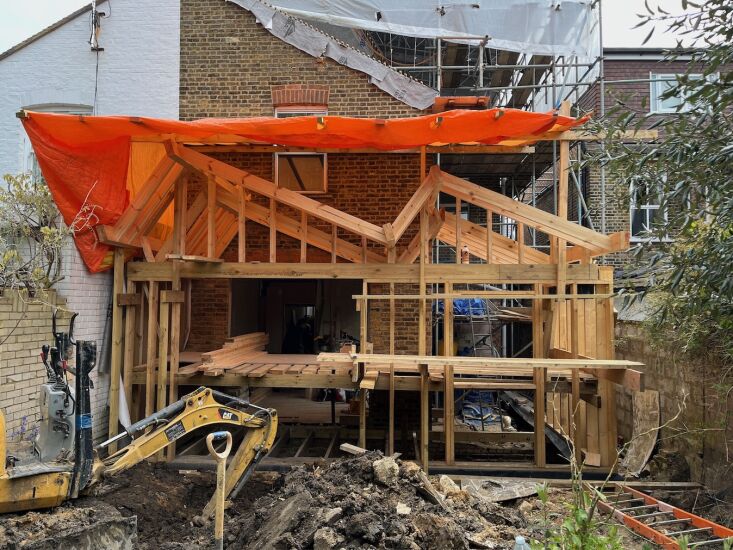 Construction phase of a home extension showing timber framing supported by screw piles instead of concrete.