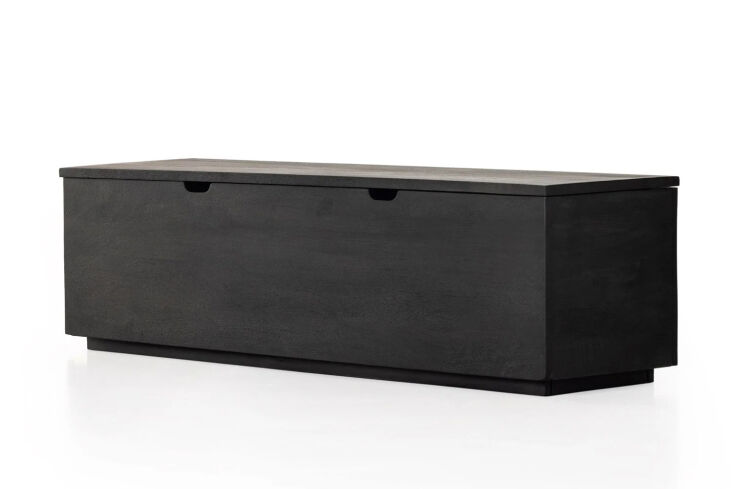 A black-finished mango wood trunk with a textured facade and contemporary styling.