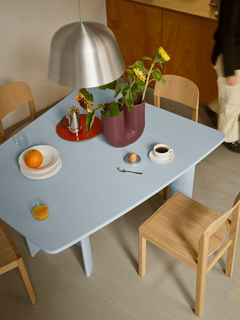 Top-down view of the Light Blue Re-norm Table set for breakfast with sunflowers and coffee.