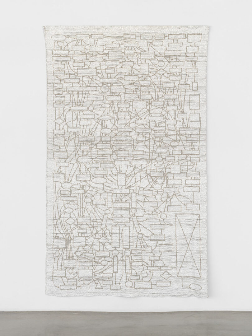 A long, vertical white tapestry featuring a textured woven pattern that mimics binary code sequences.