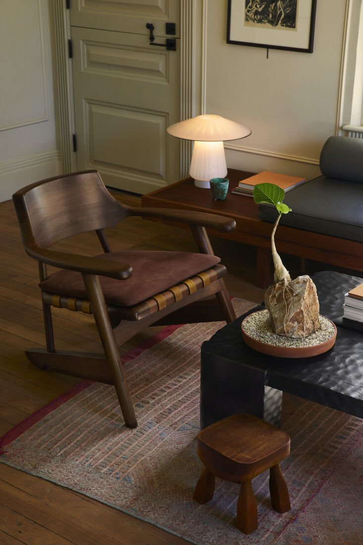 A black walnut armchair and ebonized oak coffee table in a minimalist room.