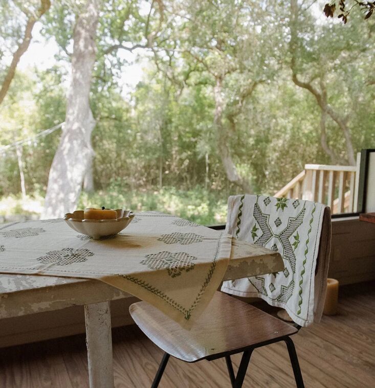The Roan Iris Heirloom Embroidered Table Throw No. 6267 featuring delicate green thread accents.