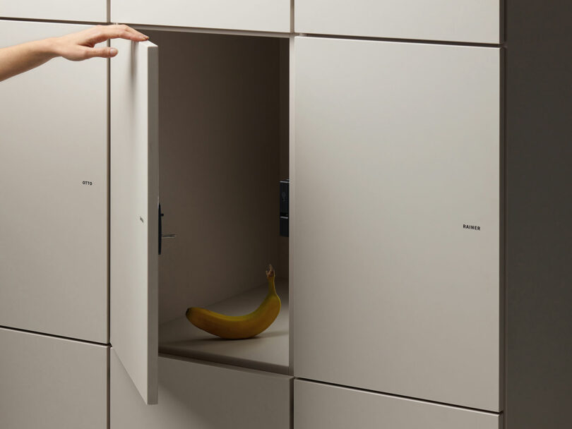 A white locker door open to reveal a single banana inside, highlighting the personal use of office storage.