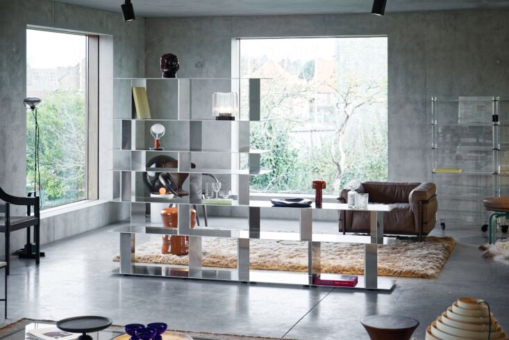 Circular and rectangular aluminum furniture components used as coffee tables and screens.