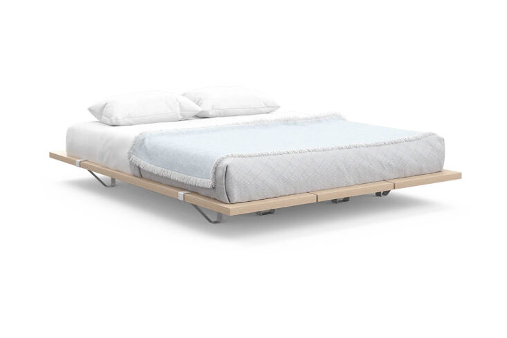 The Floyd Bed Frame in light-colored birch wood against a neutral wall.