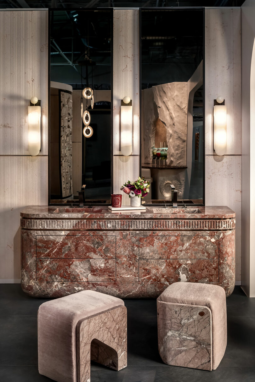 A luxury bathroom vanity featuring a rich red marble countertop and matching square stools.