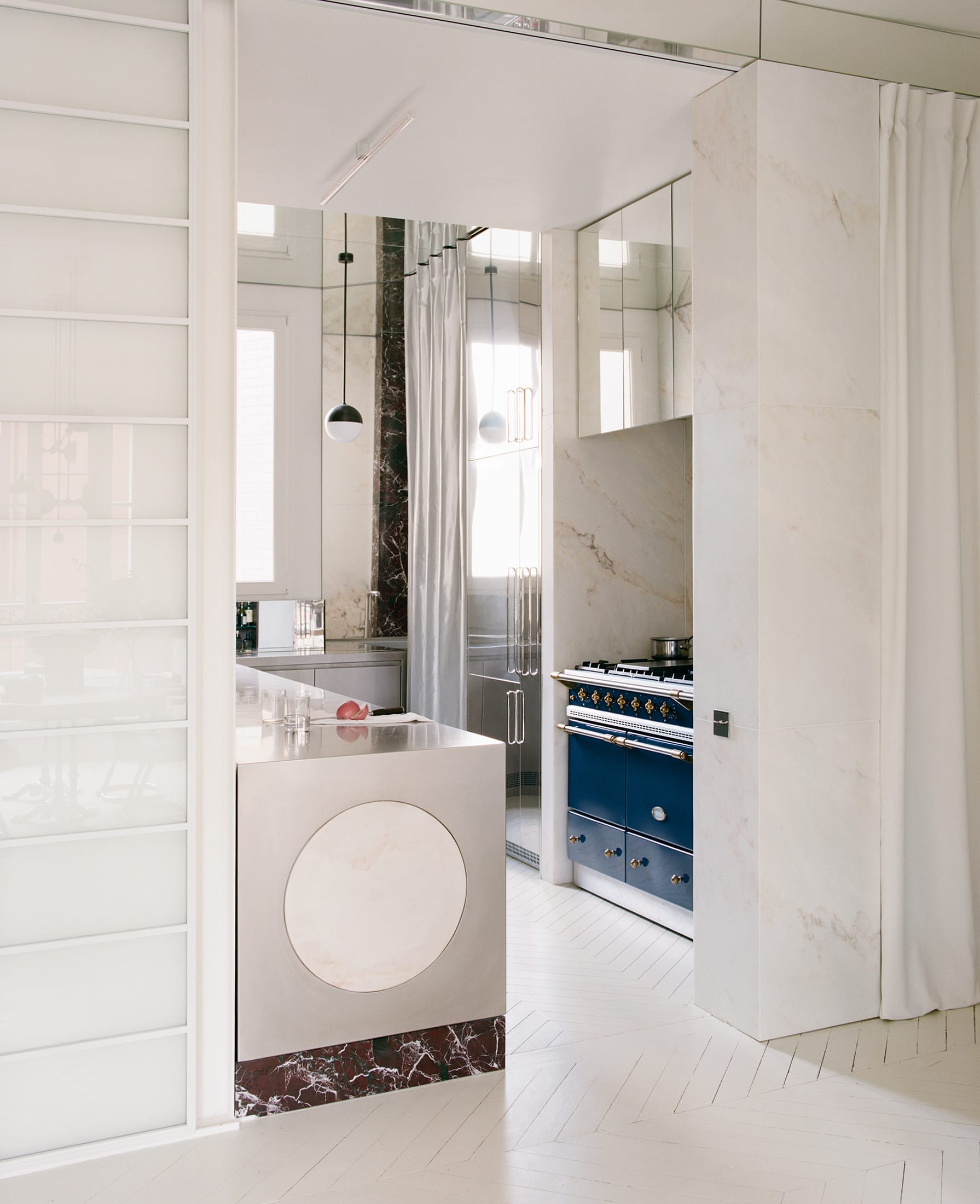 A modern kitchen area with stainless steel surfaces and architectural concrete elements.