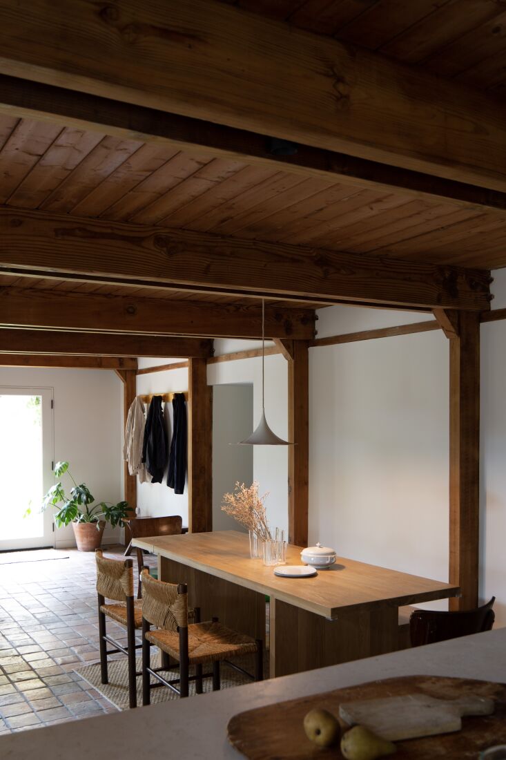 Close-up of reclaimed antique terracotta floor tiles meeting a white plastered wall.