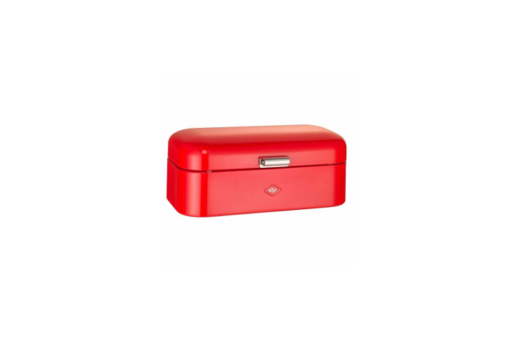 A classic red Wesco food storage container on a kitchen surface.