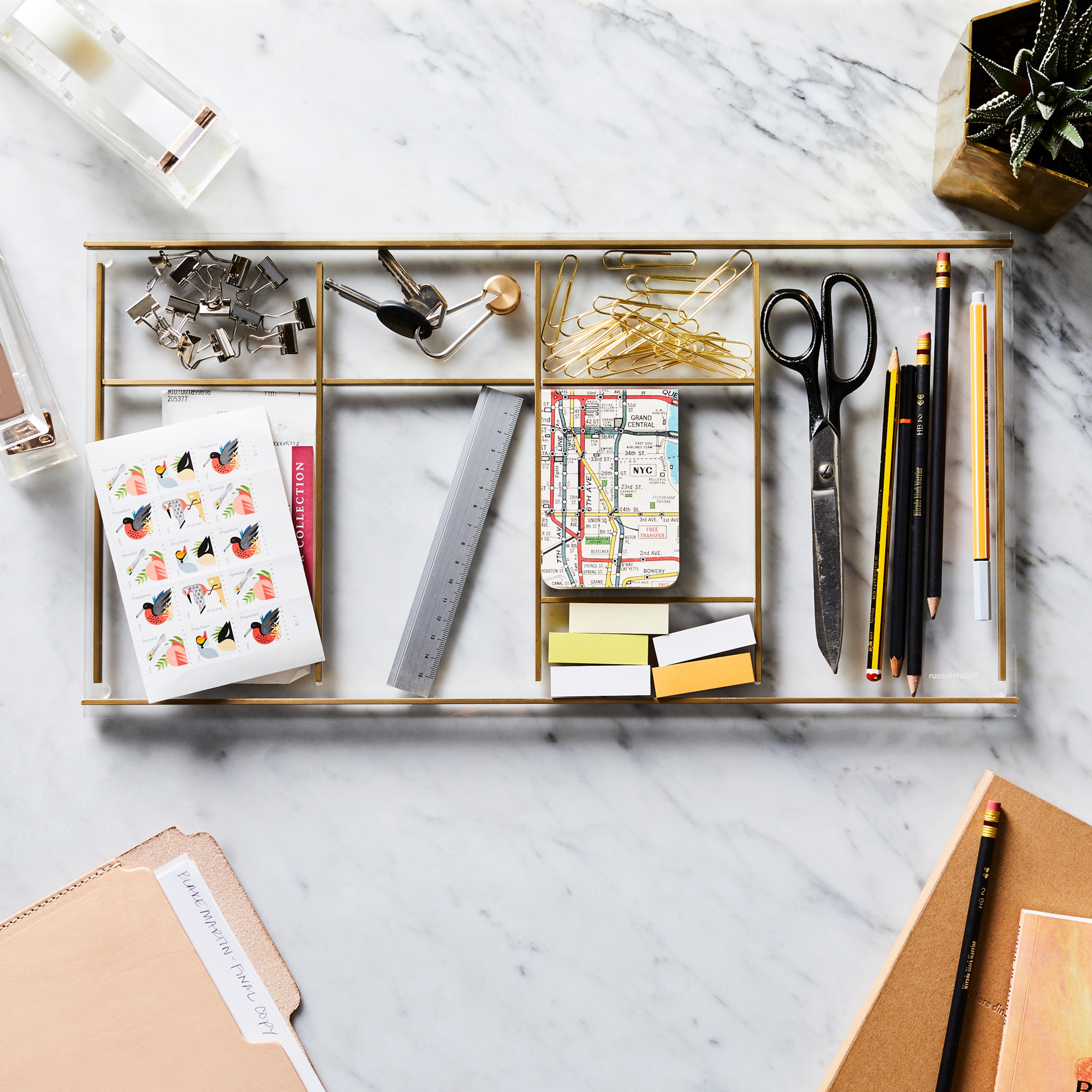 Neatly arranged desk supplies including a stapler, tape dispenser, and scissors on a clean desk surface.