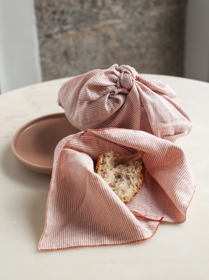 A pair of Akane Red Striped Bento Bags used for carrying items.
