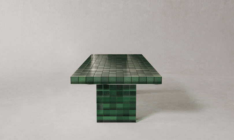 A large rectangular table with a glossy green tiled surface and a matching heavy base.