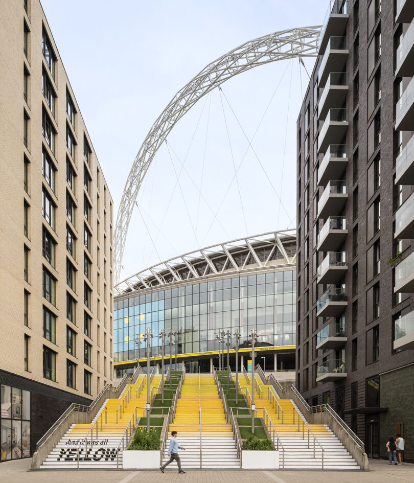 A wide-angle view of the yellow painted Spanish Steps in London, leading toward the iconic Wembley Stadium arch.