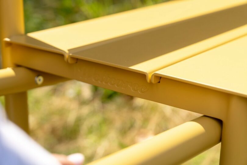 Sunlight reflecting off the yellow embossed metal frame of the Wheelbench.