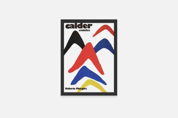 A framed Alexander Calder Galerie Maeght poster leaning against a white wall.