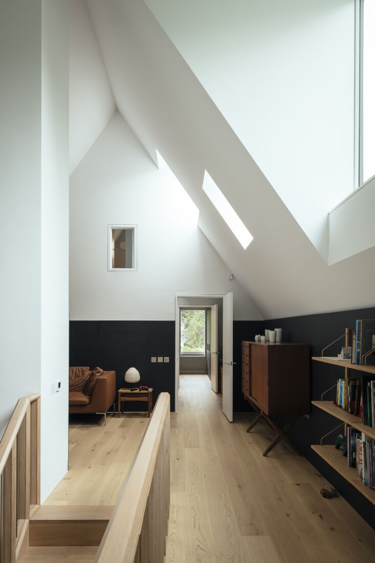 An upstairs study with oak flooring, Valchromat wood fiber wall panels, and Poul Cadovius shelving.