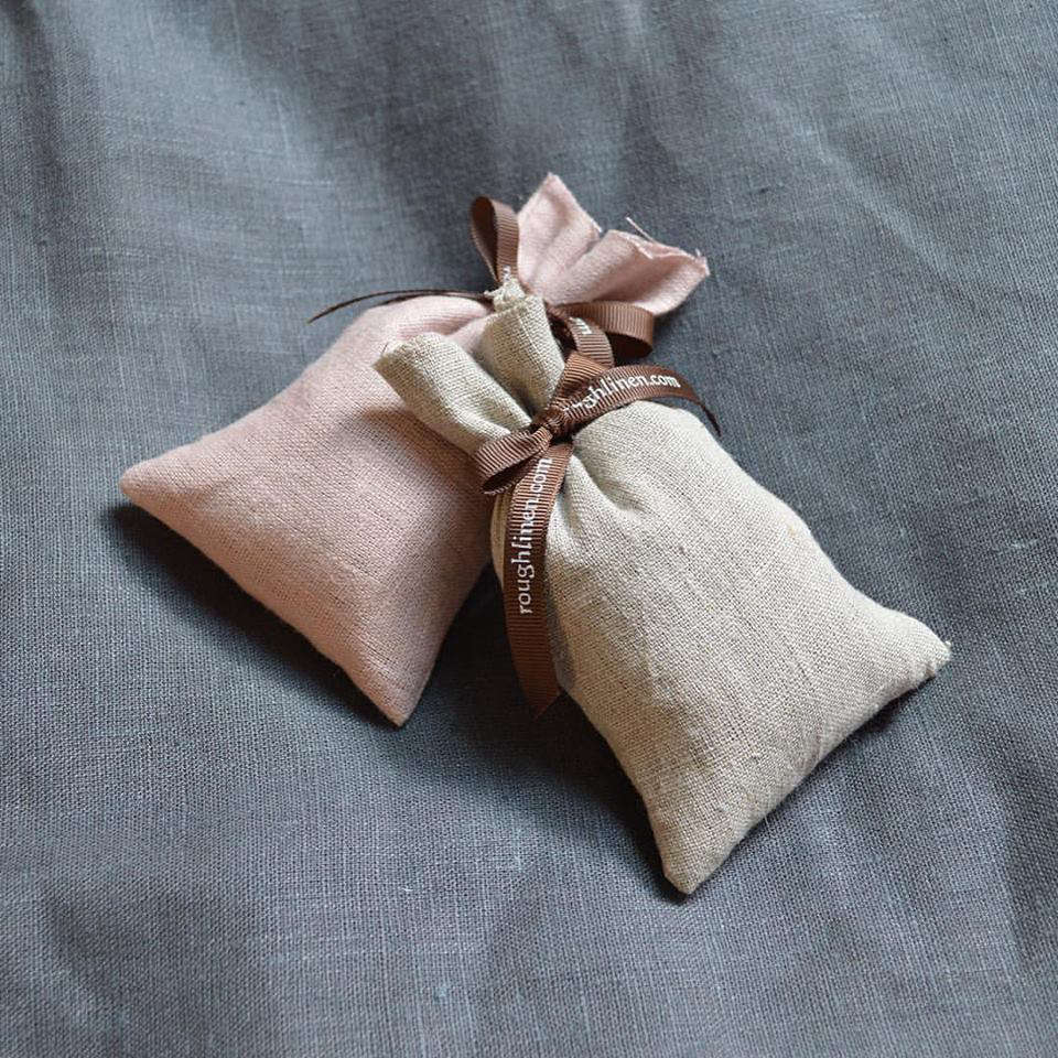 A small lavender sachet placed on a linen pillowcase.