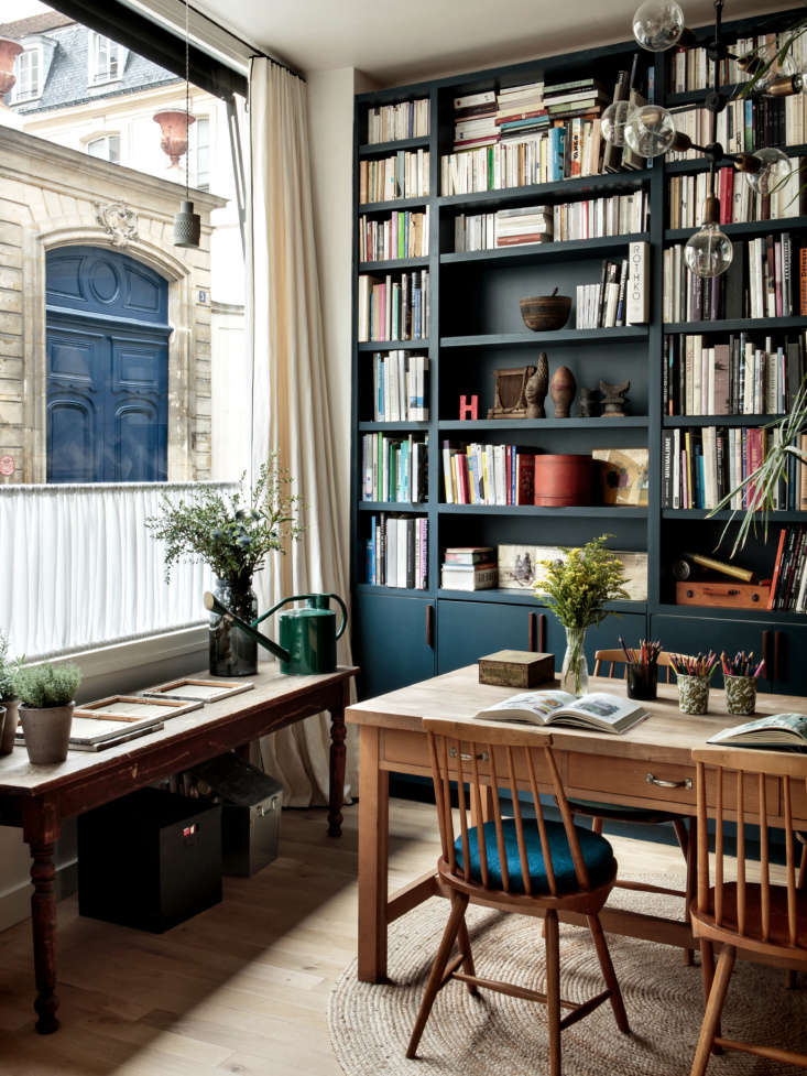 Built-in floor-to-ceiling bookshelves painted in a deep navy blue surrounding a doorway.