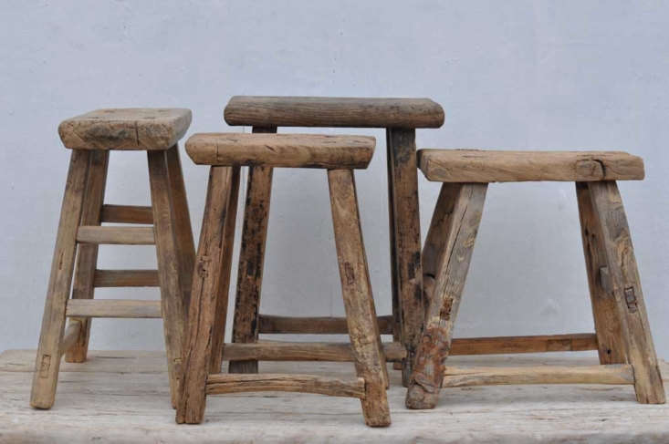 Two rustic antique wooden stools with a weathered texture.