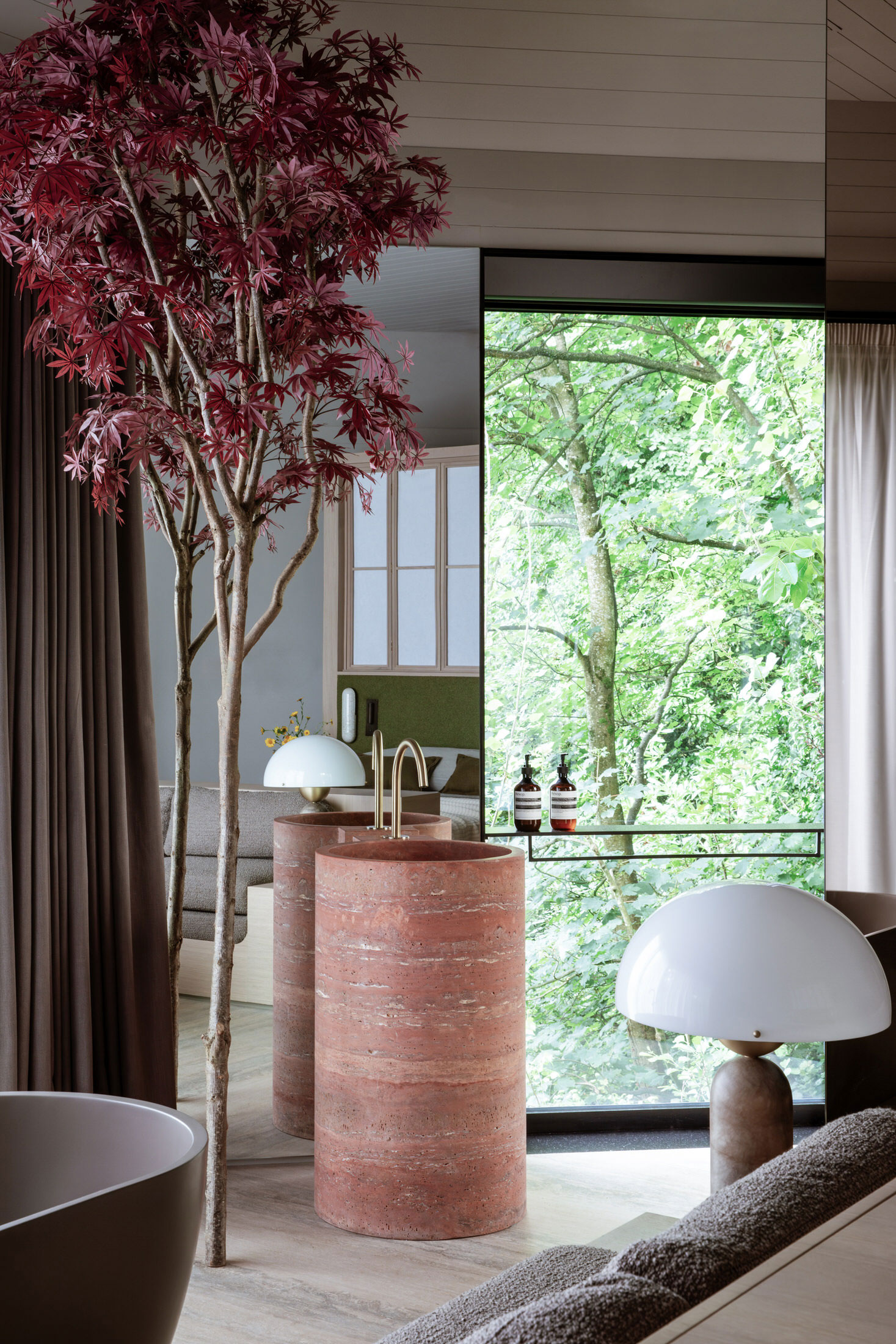 Interior detail of a suite showing a mix of timber walls, soft textiles, and minimalist furniture.