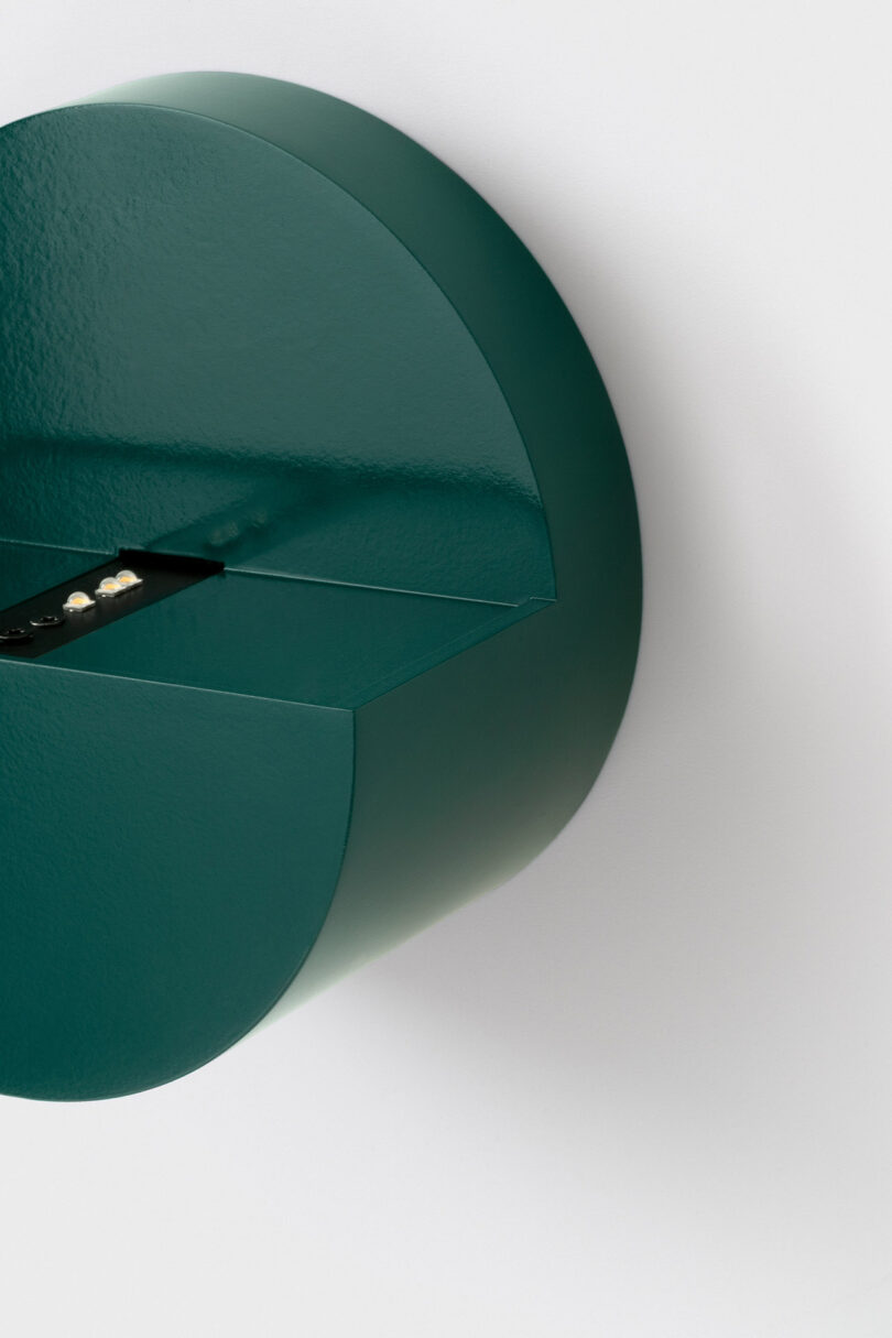 A modern dark green semi-circular wall light with a minimalist silhouette.