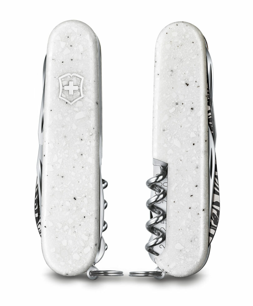 Two closed Victorinox knives with white speckled Corian scales placed side by side.