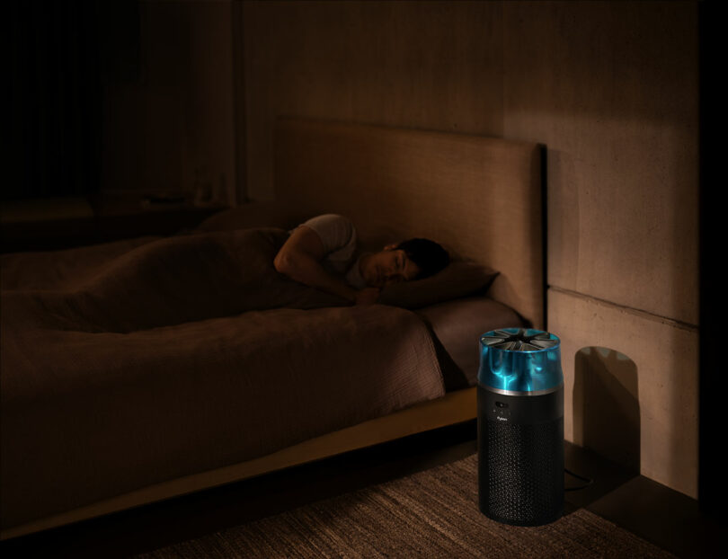 A person sleeping soundly in a bedroom with the Dyson air purifier operating quietly nearby.