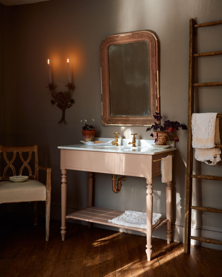 A view of the lower maple shelf and integrated brass towel rod on the washstand.