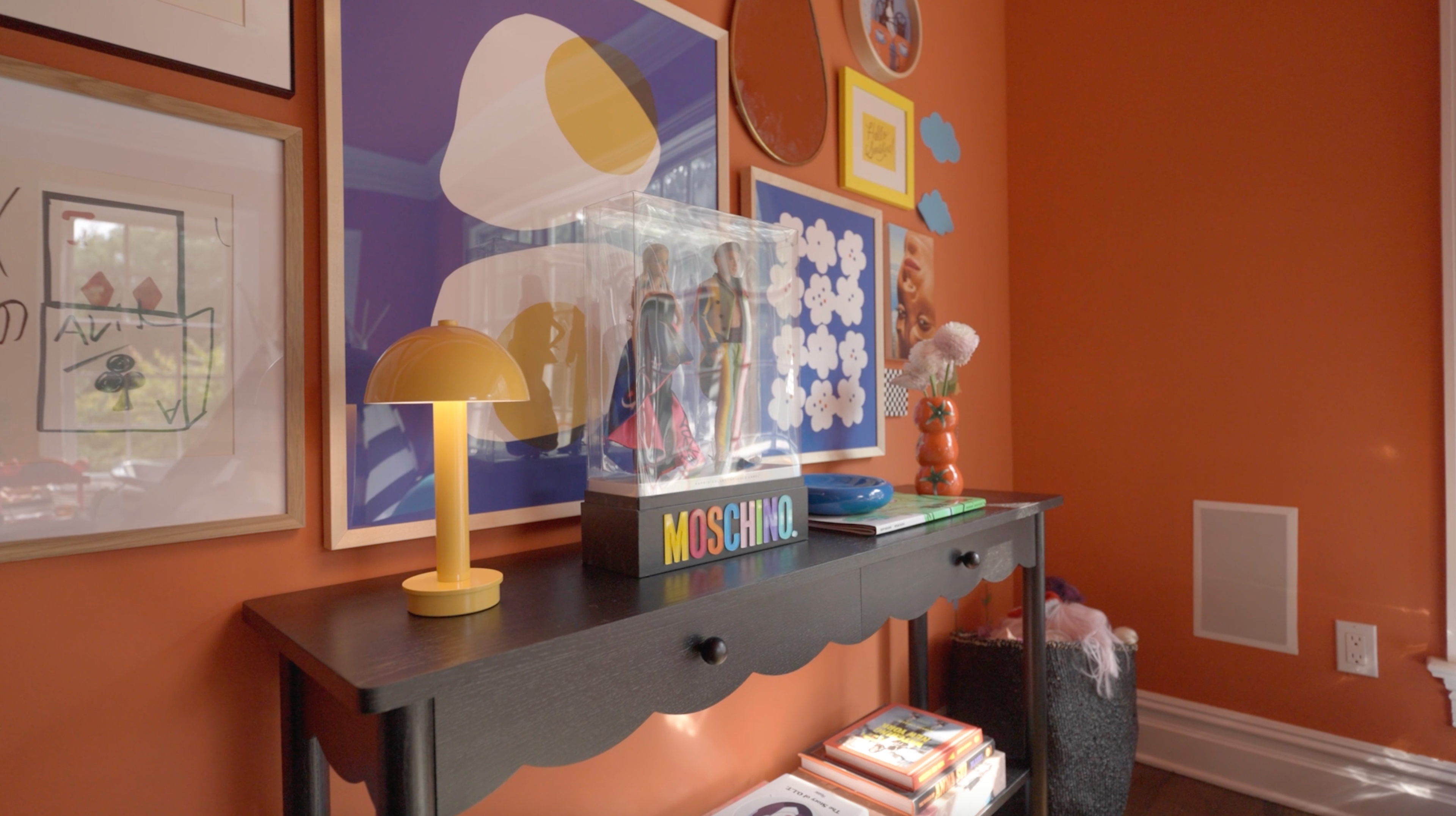 Interior space featuring Moschino-themed decor with bold graphic patterns and contrasting scales.