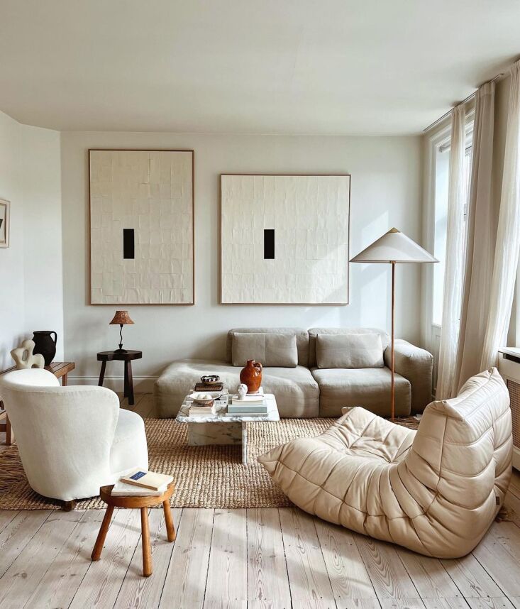 A light-colored Togo sofa in a bright Copenhagen living room with art on the walls.