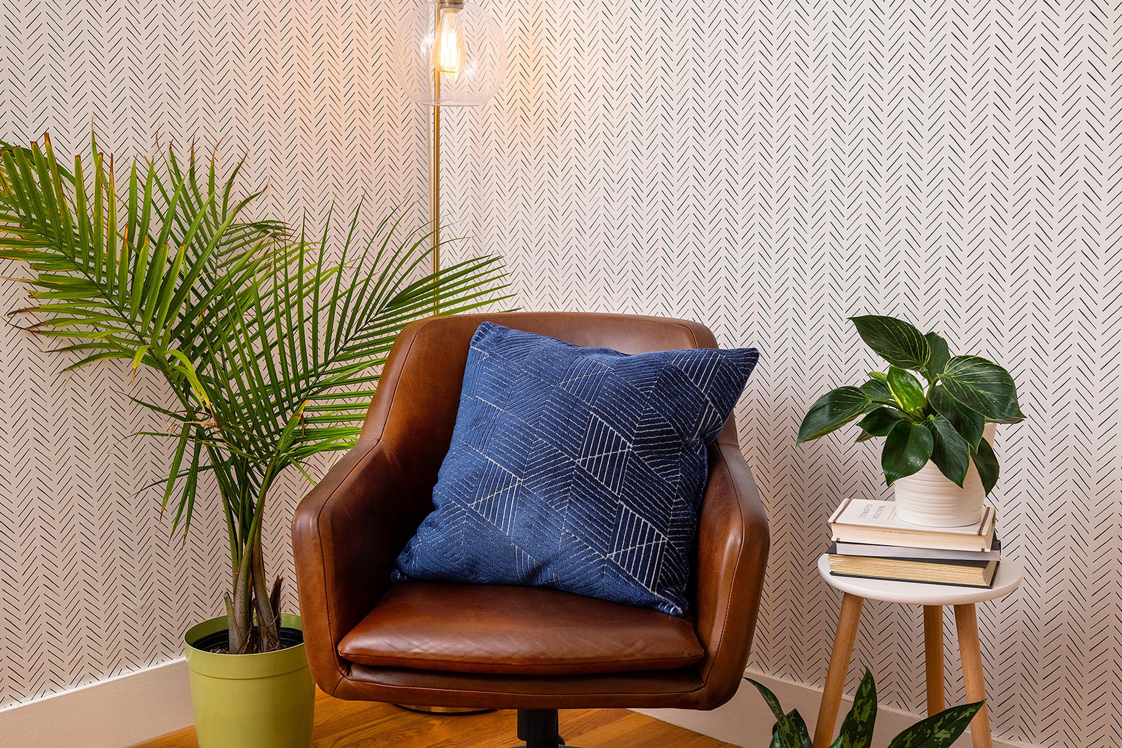 A comfortable corner chair paired with a floor lamp, ideal for taking breaks away from a computer screen.