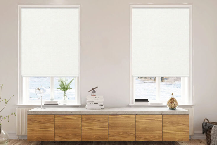 Standalone PVC side channels being applied to a window frame for use with a roller shade.