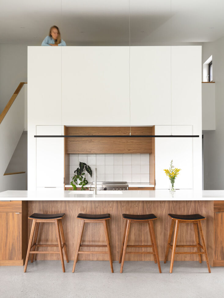 Interior view showing the open-plan kitchen and the double-height ceiling leading to a mezzanine office.