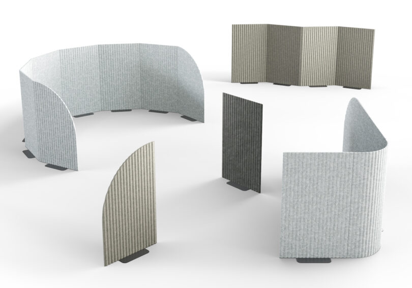 A collection of freestanding curved and flat acoustic panels in multiple shades of grey.