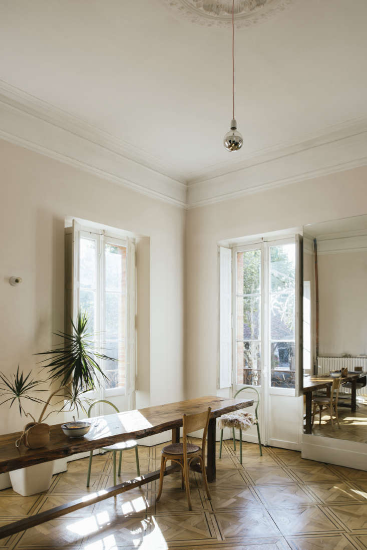 A solitary silver-tipped bulb hanging from the ceiling in a French home.