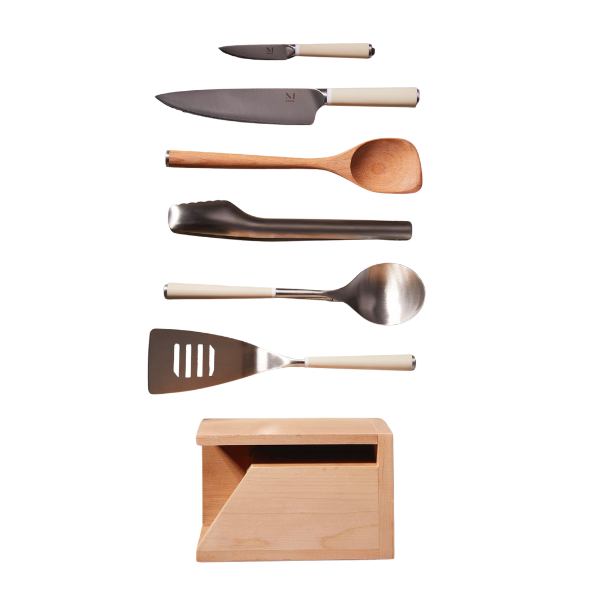 A hand sliding a pan of citrus-topped cod into a preheated oven.