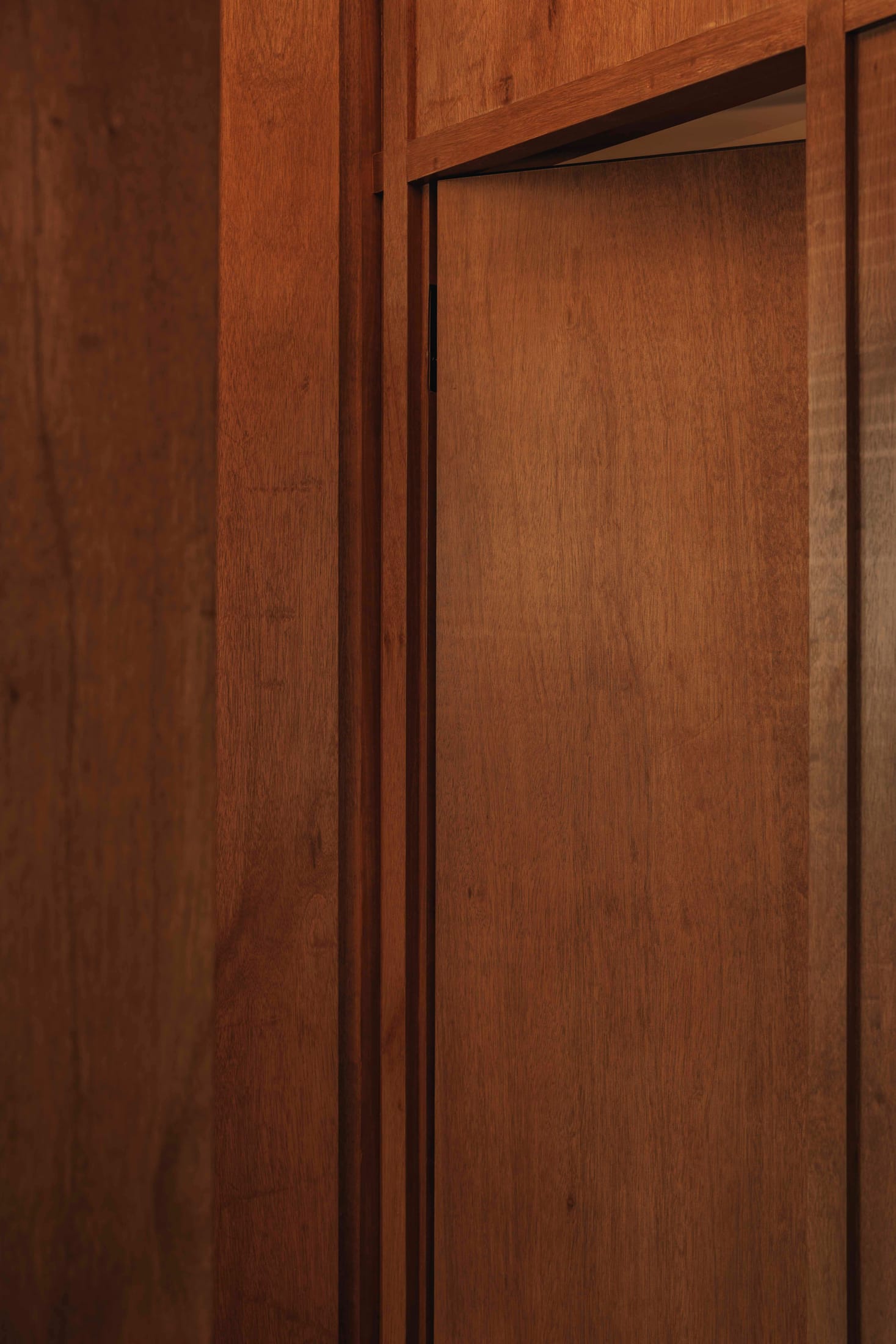 A mirrored wall reflecting a minimalist dining and workspace, creating depth.