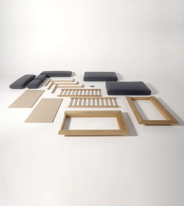 All components of the Spoke Sofa laid out as individual parts before assembly.
