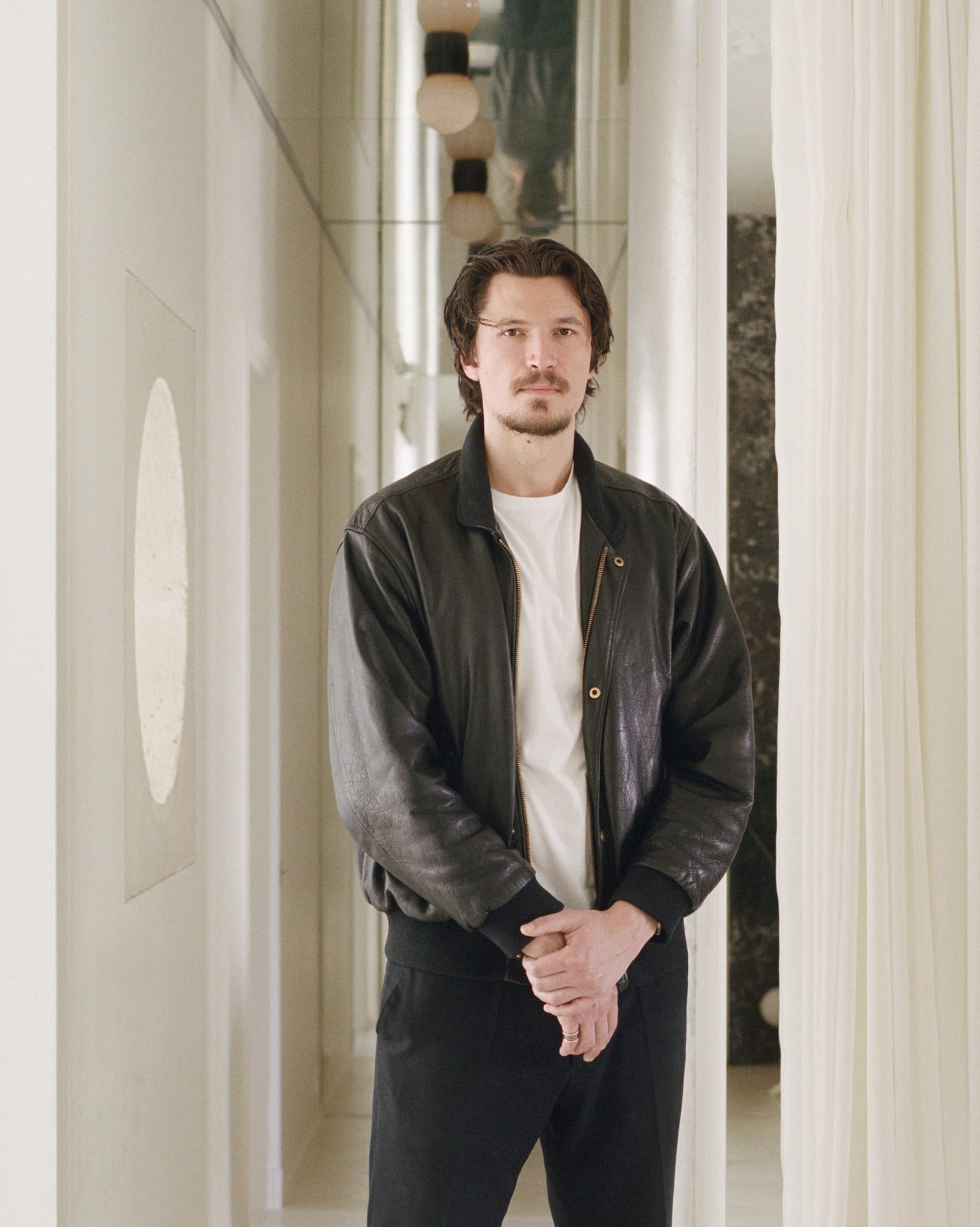 An expansive open-plan living room in a Parisian apartment with white walls and natural light.