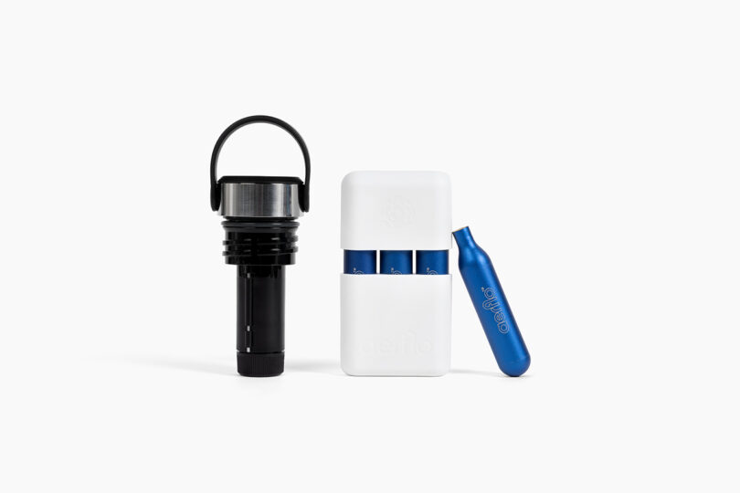 A kit containing blue Aerflo CO2 cartridges and a silver opener tool in a white carrying case.